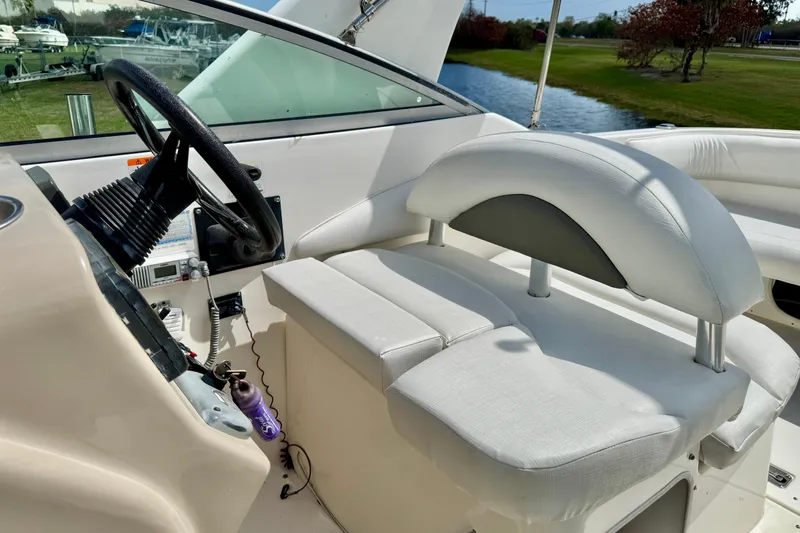 Slide: The Image of 2007 Larson Cabrio 274 boat interior with steering wheel and white seating. - 18