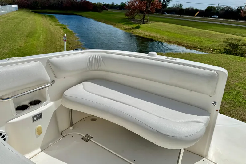 Slide: The Image of 2007 Larson Cabrio 274 boat interior with white seating near a scenic waterway. - 23