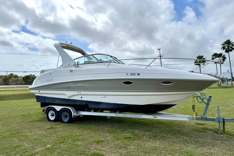 Slide: The Image of 2007 Larson Cabrio 274 boat on trailer, parked on grass under cloudy sky. - 3