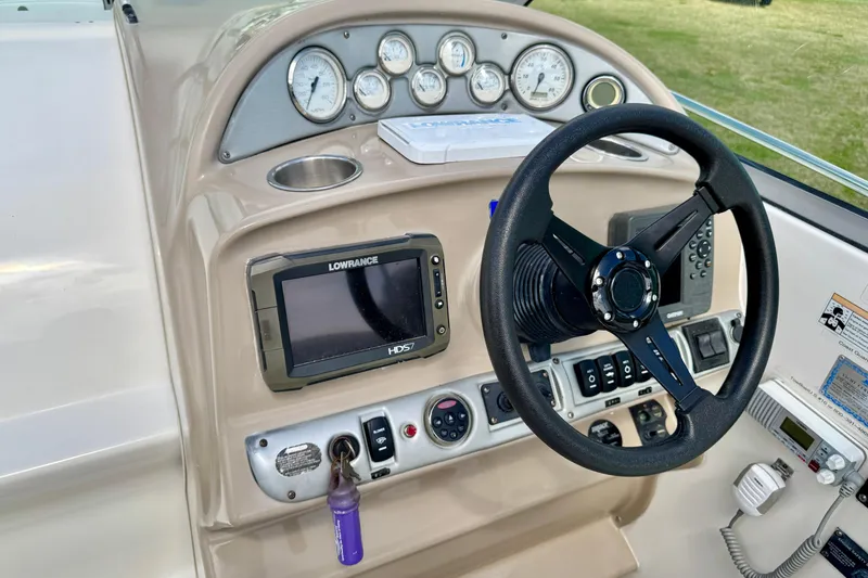 Slide: The Image of 2007 Larson Cabrio 274 dashboard with steering wheel, gauges, and Lowrance HDS7 display. - 8