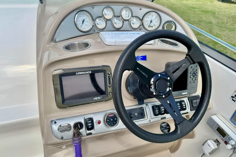 Slide: The Image of Dashboard of a 2007 Larson Cabrio 274 boat with steering wheel and navigation instruments. - 9