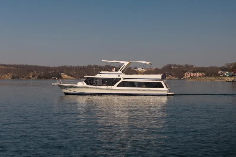 The Image of 1985 Blue Water 51 Coastal yacht cruising on a calm lake under clear skies. - 1