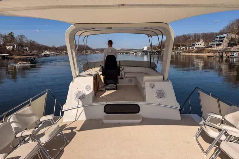 Slide: The Image of 1985 Blue Water 51 Coastal yacht cruising on a serene lake with scenic shoreline views. - 10