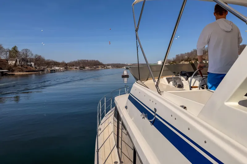 Slide: The Image of 1985 Blue Water 51 Coastal yacht cruising on a serene lake with clear skies. - 11