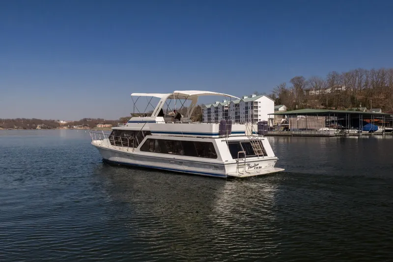 Slide: The Image of 1985 Blue Water 51 Coastal yacht cruising on a calm lake near a marina. - 17