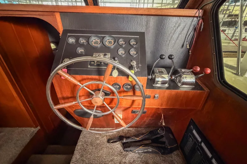 Slide: The Image of 1984 Blue Water 51 Coastal boat helm with wooden steering wheel and control panel. - 22