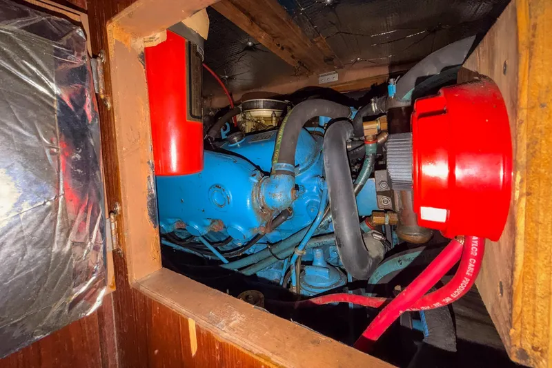 Slide: The Image of Engine compartment of a 1984 Blue Water 51 Coastal boat, featuring red and blue components. - 28