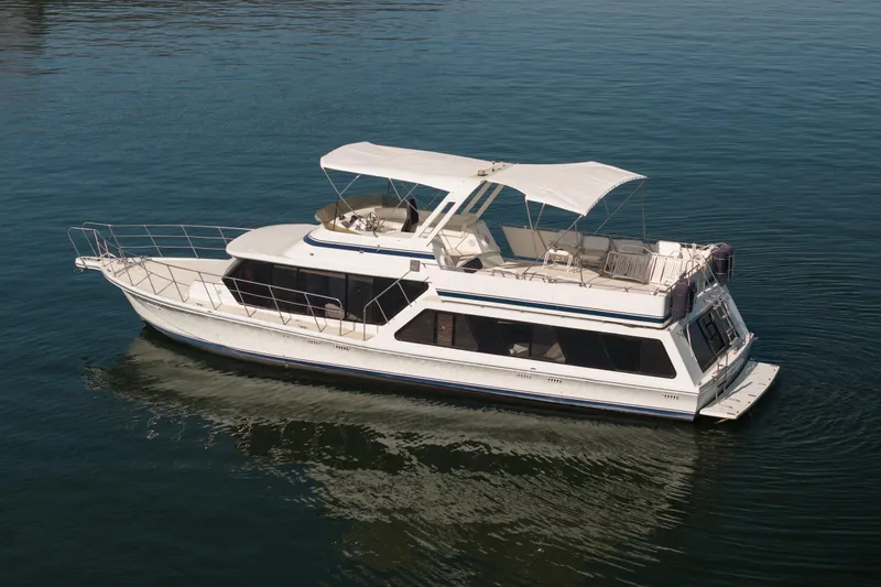 Slide: The Image of 1985 Blue Water 51 Coastal yacht on calm water, featuring a spacious deck and canopy. - 3