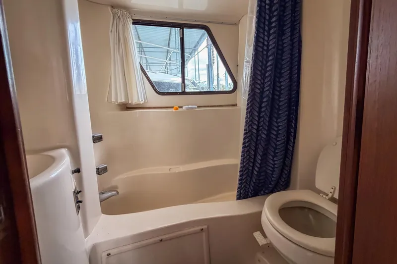 Slide: The Image of 1984 Blue Water 51 Coastal yacht bathroom with shower, toilet, and window. - 31
