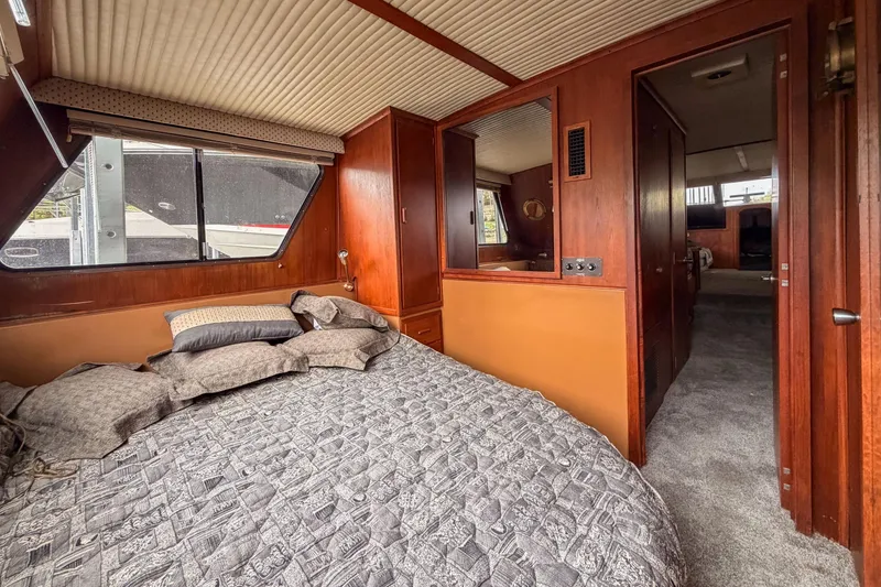 Slide: The Image of Cozy bedroom interior of 1984 Blue Water 51 Coastal yacht with wood paneling and large window. - 33