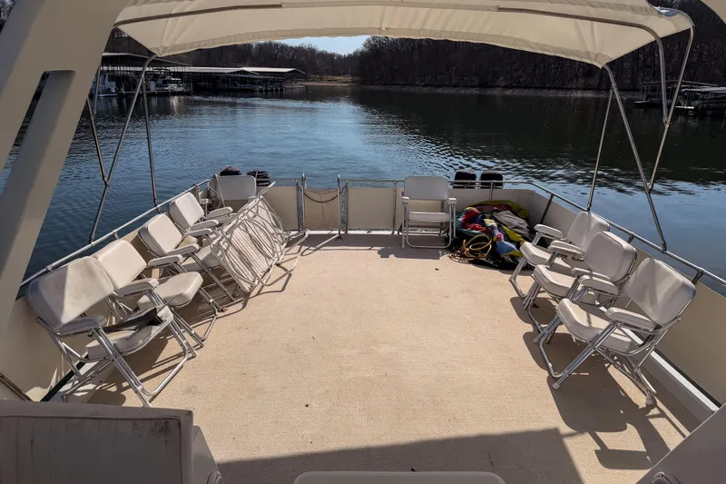 Slide: The Image of Spacious deck of 1985 Blue Water 51 Coastal boat with seating, overlooking serene water. - 8