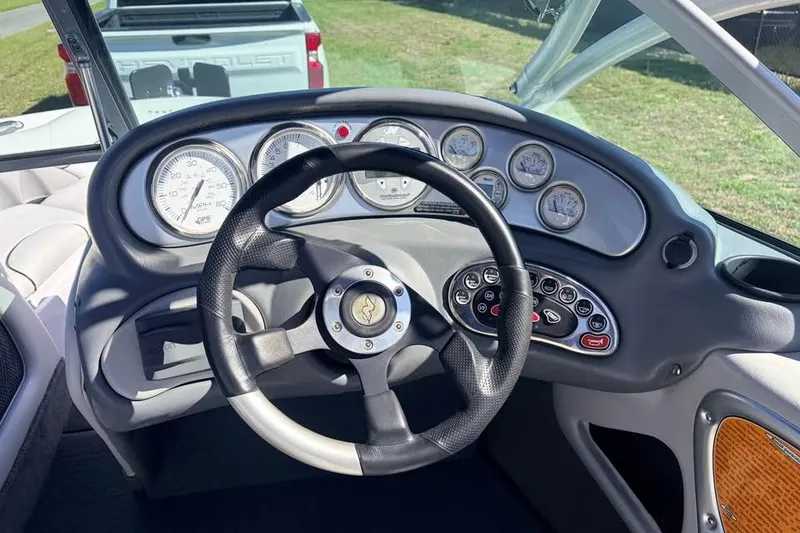 Slide: The Image of Dashboard of a 2005 Nautique Super Air Nautique 210 boat with steering wheel and gauges. - 10