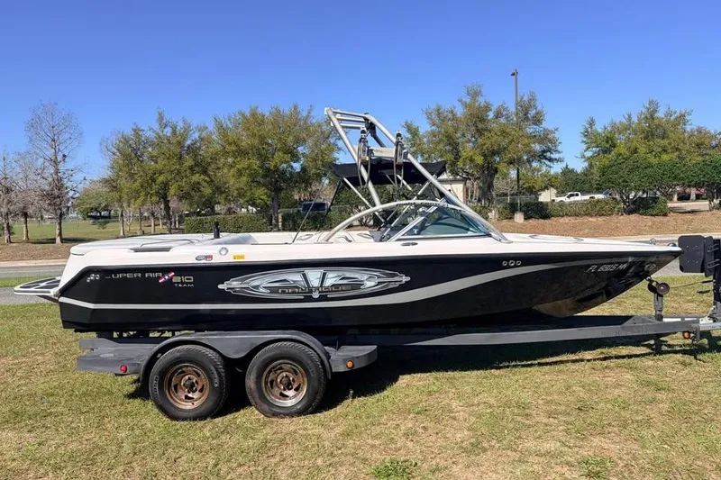 Slide: The Image of 2005 Nautique Super Air Nautique 210 boat on trailer, parked on grass. - 2