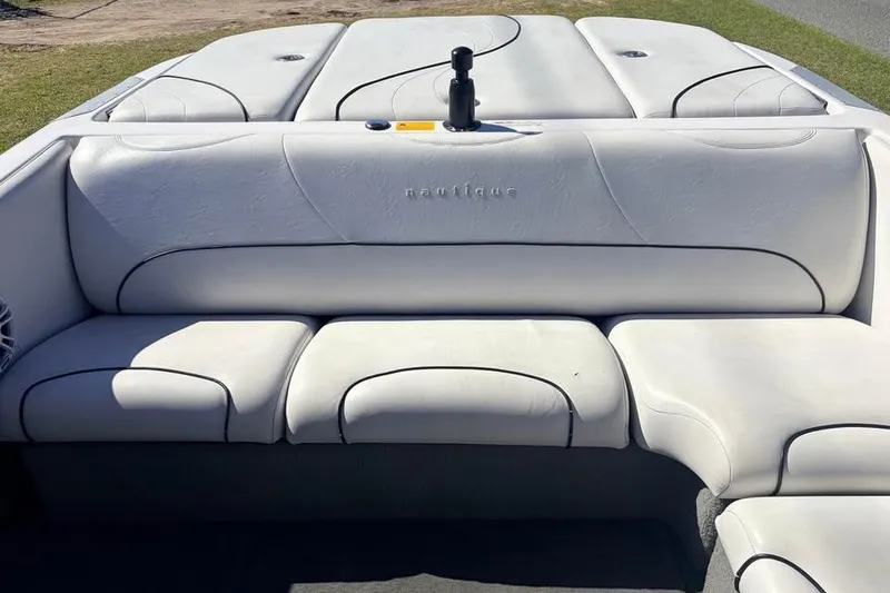 Slide: The Image of 2005 Nautique Super Air Nautique 210 boat interior with white cushioned seating. - 6