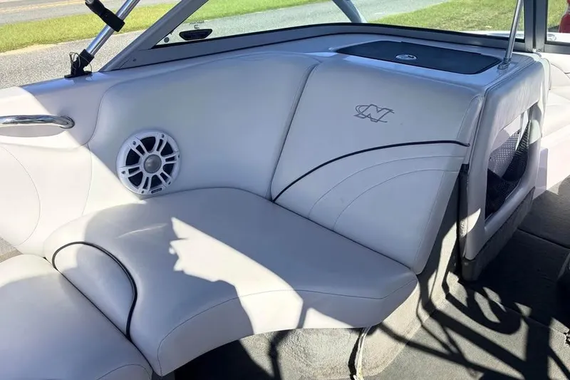 Slide: The Image of 2005 Nautique Super Air Nautique 210 interior with white seating and speaker. - 9