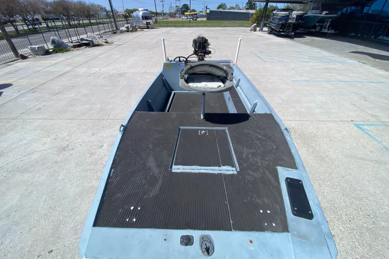 Slide: The Image of 2009 Pro-Drive X Series 17' boat with open deck and motor, parked outdoors. - 10