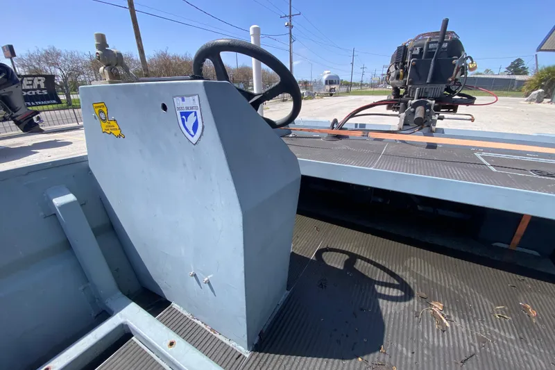 Slide: The Image of 2009 Pro-Drive X Series 17' boat interior with steering wheel and motor, outdoors. - 14