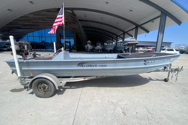 Slide: The Image of 2009 Pro-Drive X Series 17' boat on trailer, parked outdoors with American flag. - 2