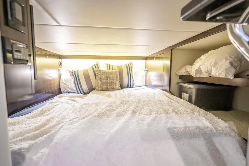 Slide: The Image of Cozy cabin interior of 2022 Cruisers Yachts 38 GLS OB with plush bedding and pillows. - 34