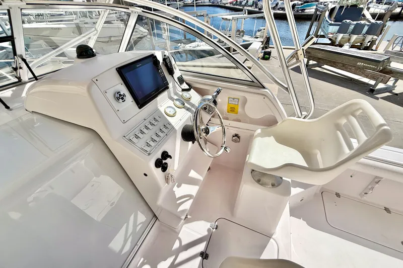 Slide: The Image of 2005 Pro-Line 29 Walkaround boat cockpit with steering wheel and control panel. - 10