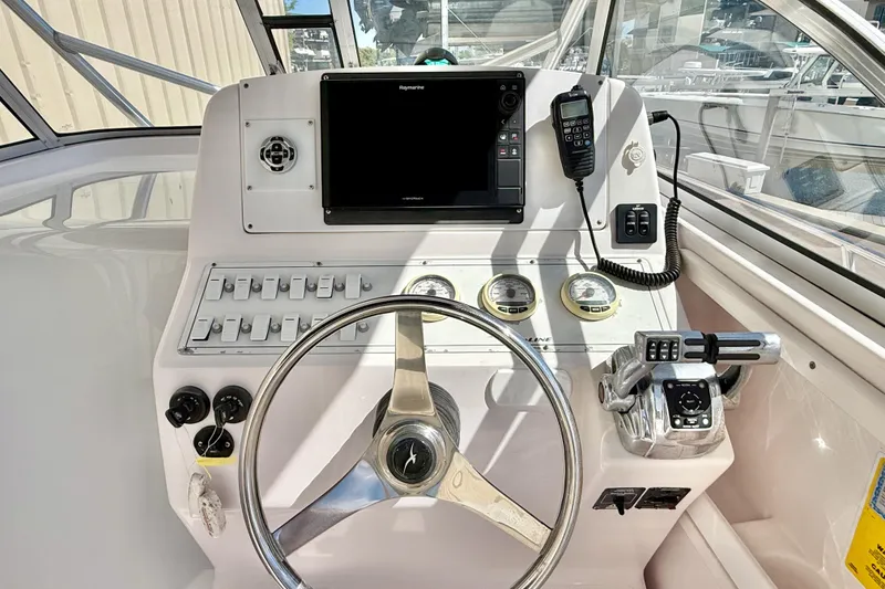 Slide: The Image of 2005 Pro-Line 29 Walkaround boat helm with steering wheel, gauges, and navigation equipment. - 11