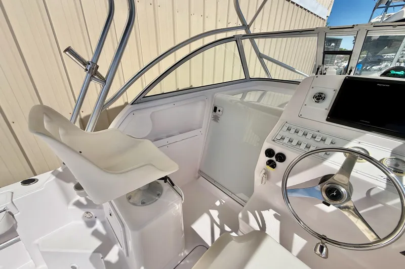 Slide: The Image of 2005 Pro-Line 29 Walkaround boat cockpit with steering wheel and control panel. - 12