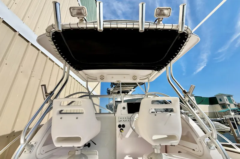 Slide: The Image of 2005 Pro-Line 29 Walkaround boat interior with helm and seating under a clear blue sky. - 13