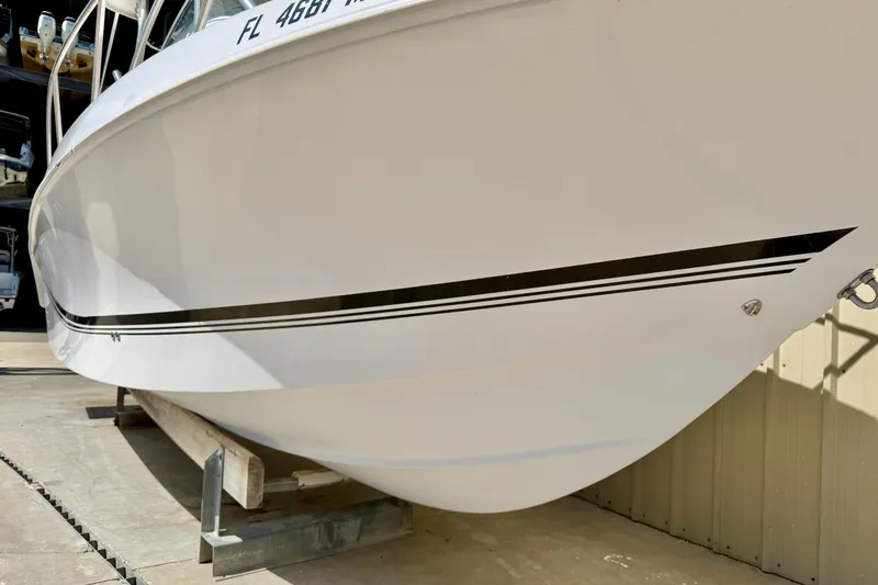 Slide: The Image of 2005 Pro-Line 29 Walkaround boat hull with registration number, docked indoors. - 2