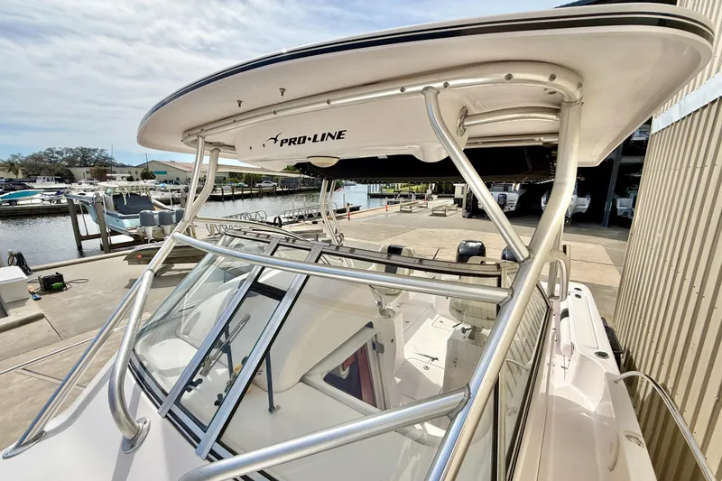 Slide: The Image of 2005 Pro-Line 29 Walkaround boat docked at marina, showcasing sleek design and sturdy structure. - 27