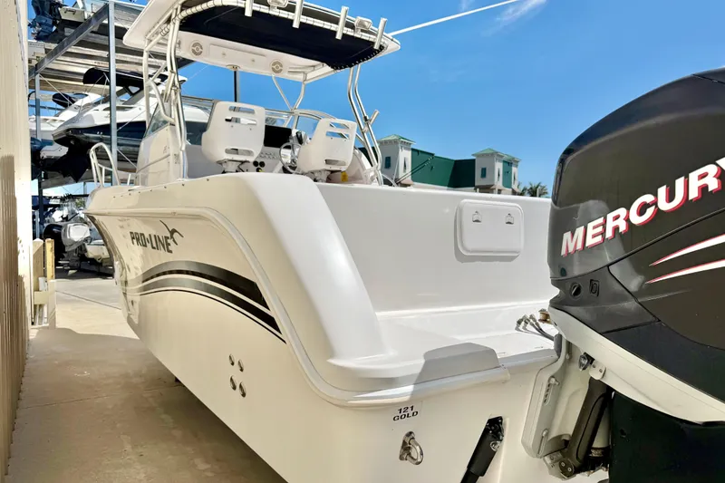 Slide: The Image of 2005 Pro-Line 29 Walkaround boat with Mercury engine, docked under clear blue sky. - 4