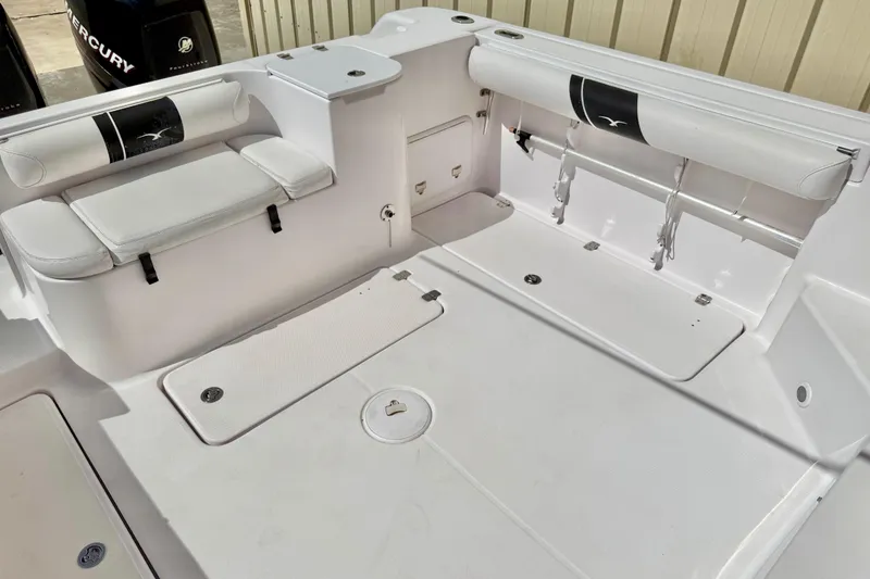 Slide: The Image of 2005 Pro-Line 29 Walkaround boat interior with white seating and storage compartments. - 8