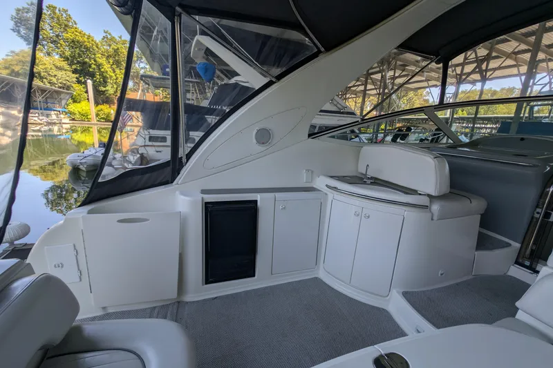 Slide: The Image of 2004 Maxum 3700 SY yacht interior with seating, cabinets, and a small sink. - 20