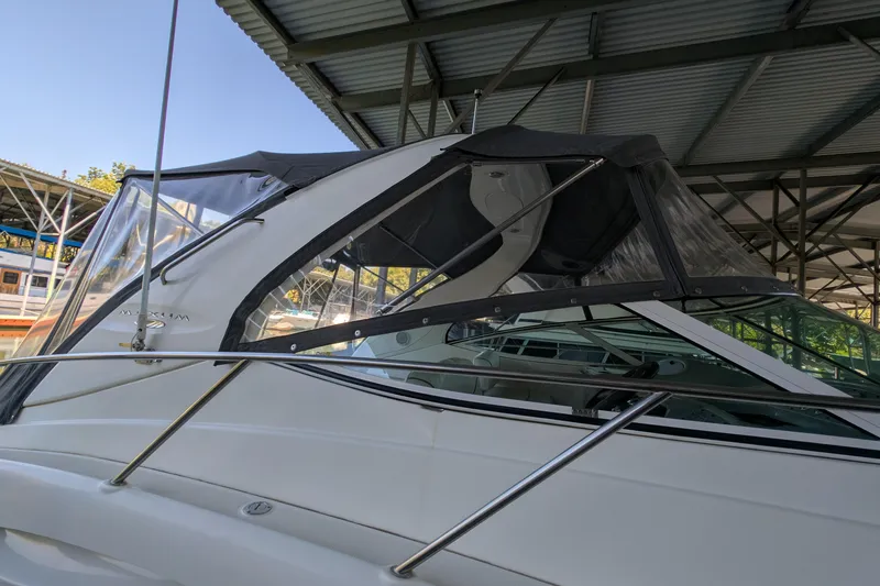 Slide: The Image of 2004 Maxum 3700 SY yacht under covered dock, featuring sleek design and clear canopy. - 8