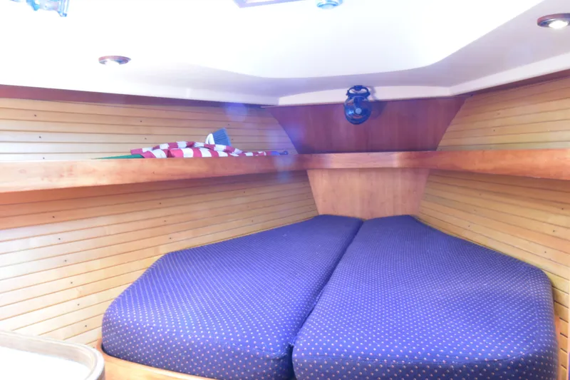 Slide: The Image of 2004 Sabre 386 yacht interior with cozy V-berth and wooden paneling. - 12