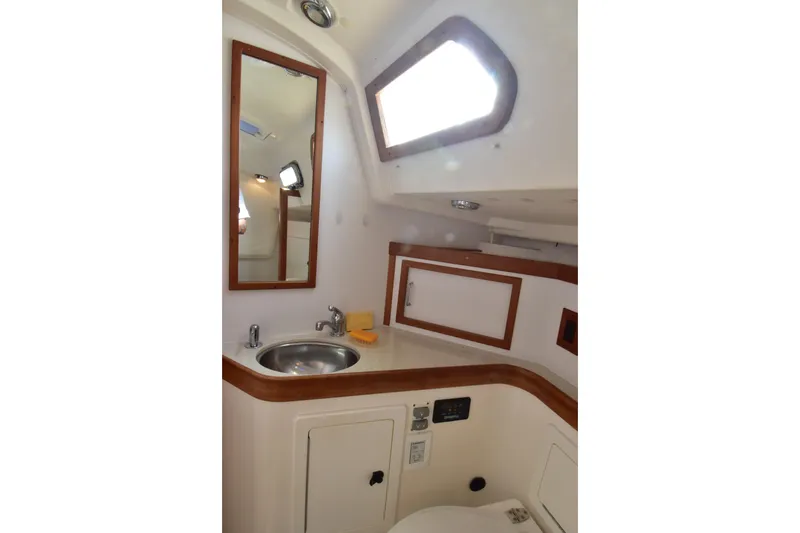 Slide: The Image of 2004 Sabre 386 yacht bathroom with sink, mirror, and wooden accents. - 16
