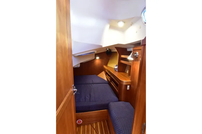 Slide: The Image of Cozy cabin interior of 2004 Sabre 386 sailboat with wooden furnishings and blue bedding. - 18