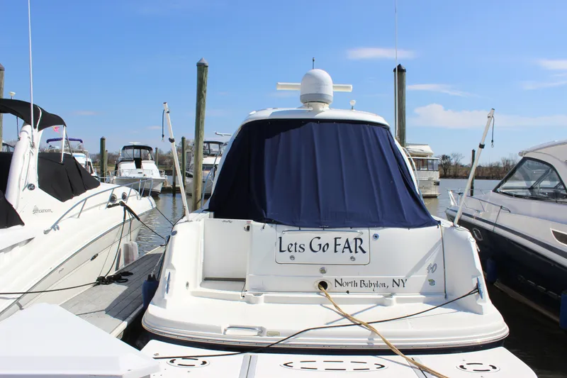 Slide: The Image of 2006 Sea Ray 40 Sundancer docked at marina, rear view with blue cover. - 2