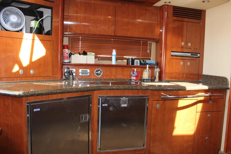 Slide: The Image of Luxurious 2006 Sea Ray 40 Sundancer yacht kitchen with wooden cabinetry and modern appliances. - 25