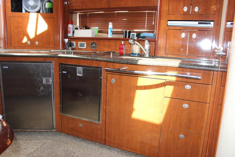 Slide: The Image of Luxurious 2006 Sea Ray 40 Sundancer yacht kitchen with wood cabinetry and modern appliances. - 28