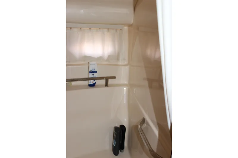 Slide: The Image of Bathroom interior of 2006 Sea Ray 40 Sundancer yacht, featuring shower amenities and curtain. - 41