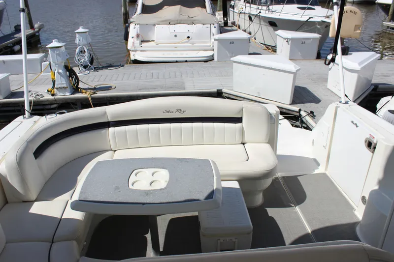 Slide: The Image of 2006 Sea Ray 40 Sundancer yacht interior with cushioned seating and table at dock. - 8