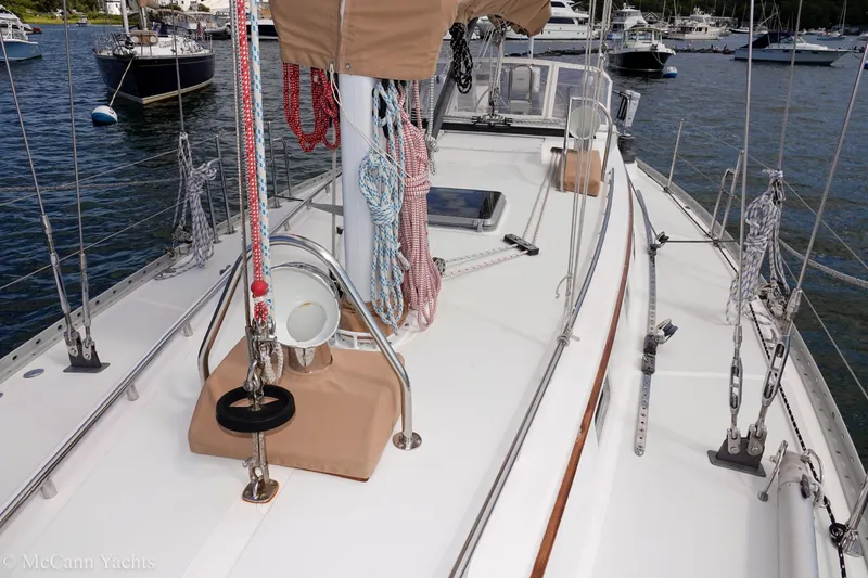 Slide: The Image of 1993 Alden 43 Aft Cockpit sailboat deck with rigging and moored yachts in background. - 21