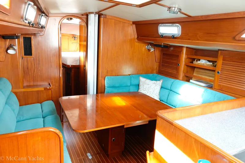 Slide: The Image of Cozy interior of 1993 Alden 43 Aft Cockpit yacht with wooden furnishings and teal seating. - 32