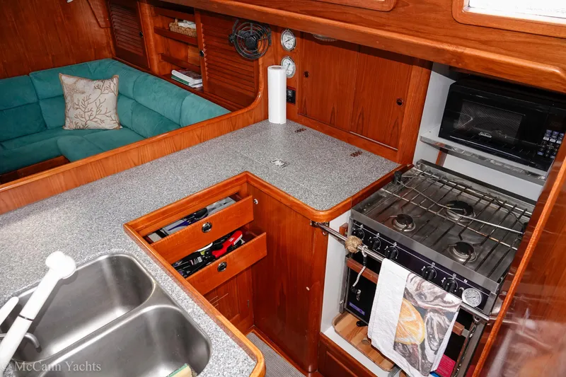 Slide: The Image of Cozy kitchen in 1993 Alden 43 Aft Cockpit yacht with stove, sink, and seating area. - 43
