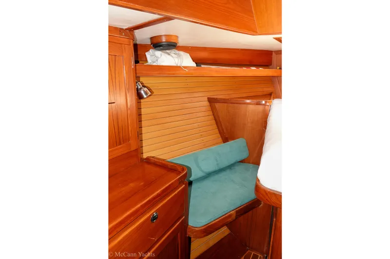 Slide: The Image of Interior of 1993 Alden 43 Aft Cockpit yacht with wooden cabinetry and teal seating. - 44