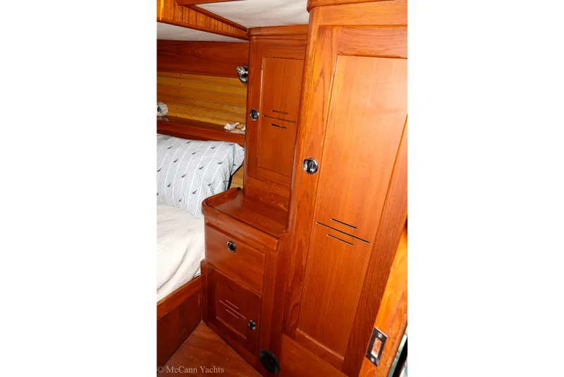 Slide: The Image of Interior of 1993 Alden 43 Aft Cockpit yacht with wooden cabinetry and cozy bedding. - 58
