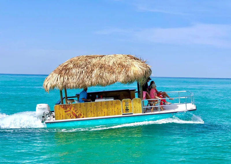 Slide: The Image of 2023 Beachcat 23 Catamaran with tiki hut roof cruising on turquoise ocean waters. - 6