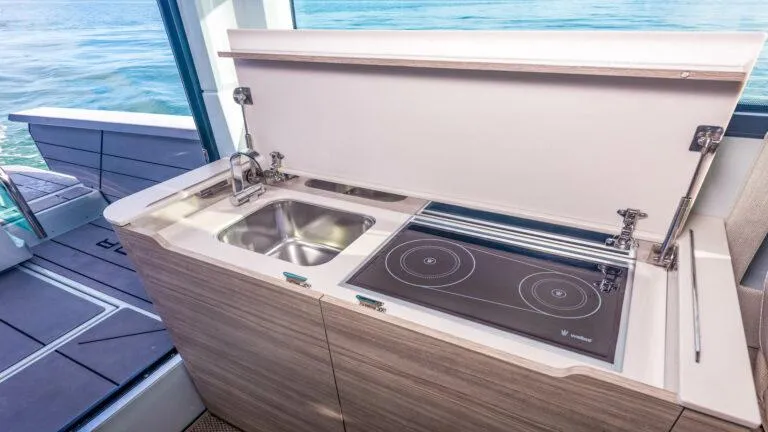 Slide: The Image of Modern kitchenette on 2025 Saxdor 320 GTC yacht with sink and induction cooktop. - 6