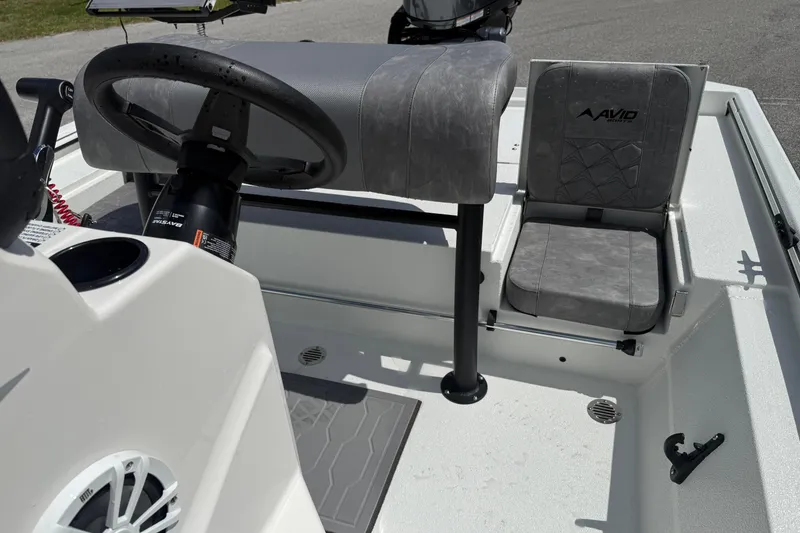 Slide: The Image of Interior of 2026 Avid 20 Rogue CC boat with steering wheel and seating. - 12