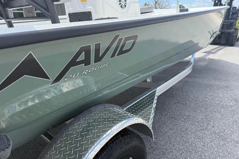 Slide: The Image of 2026 Avid 20 Rogue CC boat on a trailer, showcasing sleek design and branding. - 2